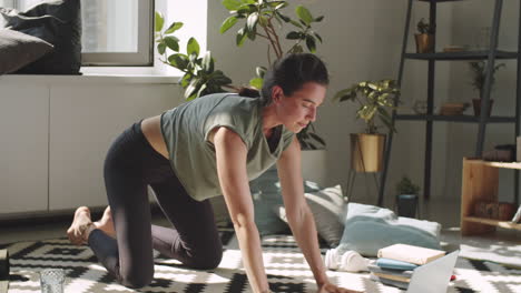 Woman Practicing Yoga with Online Class on Laptop