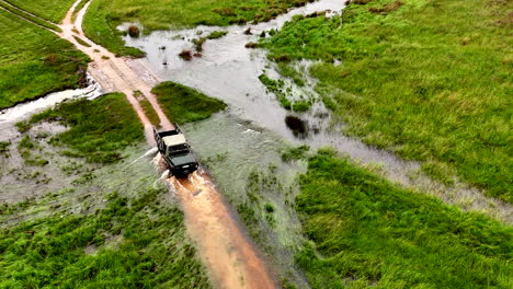 4x4 pickup reverse through flooded dirt road crossing to avoid danger, aerial