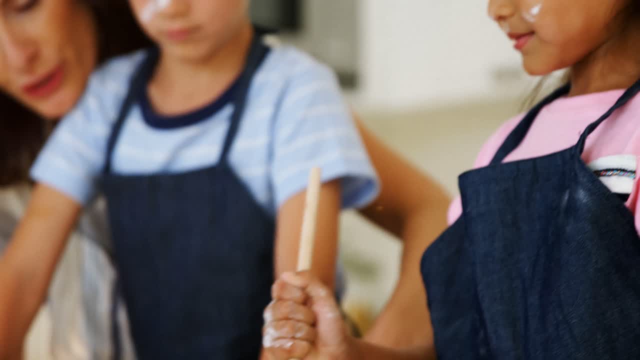 madre e hijos preparando galletas en la cocina