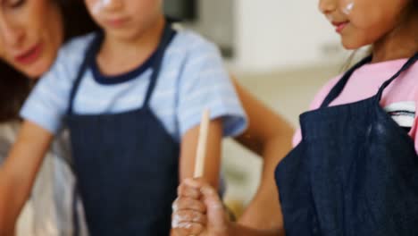 mother and kids preparing cookies in kitchen