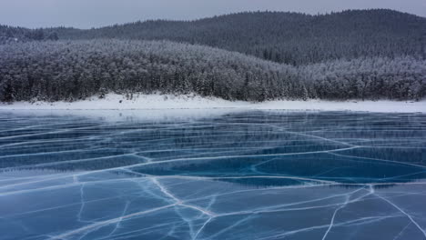 stunning frozen lake with intricate ice cracks and snowy forest