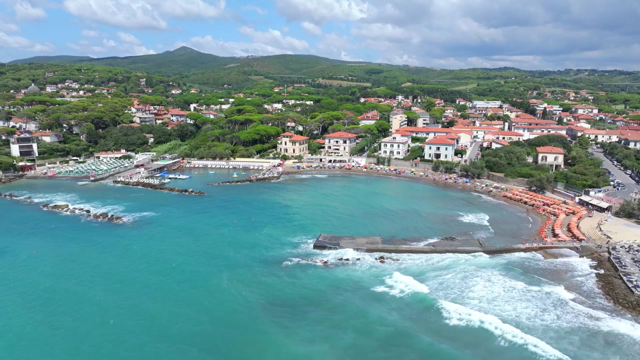 Lunghe onde che si infrangono sulle spiagge di Castiglioncello, Italia, una località toscana rinomata per i benestanti.