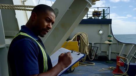 man on a ship's deck performing an inspection