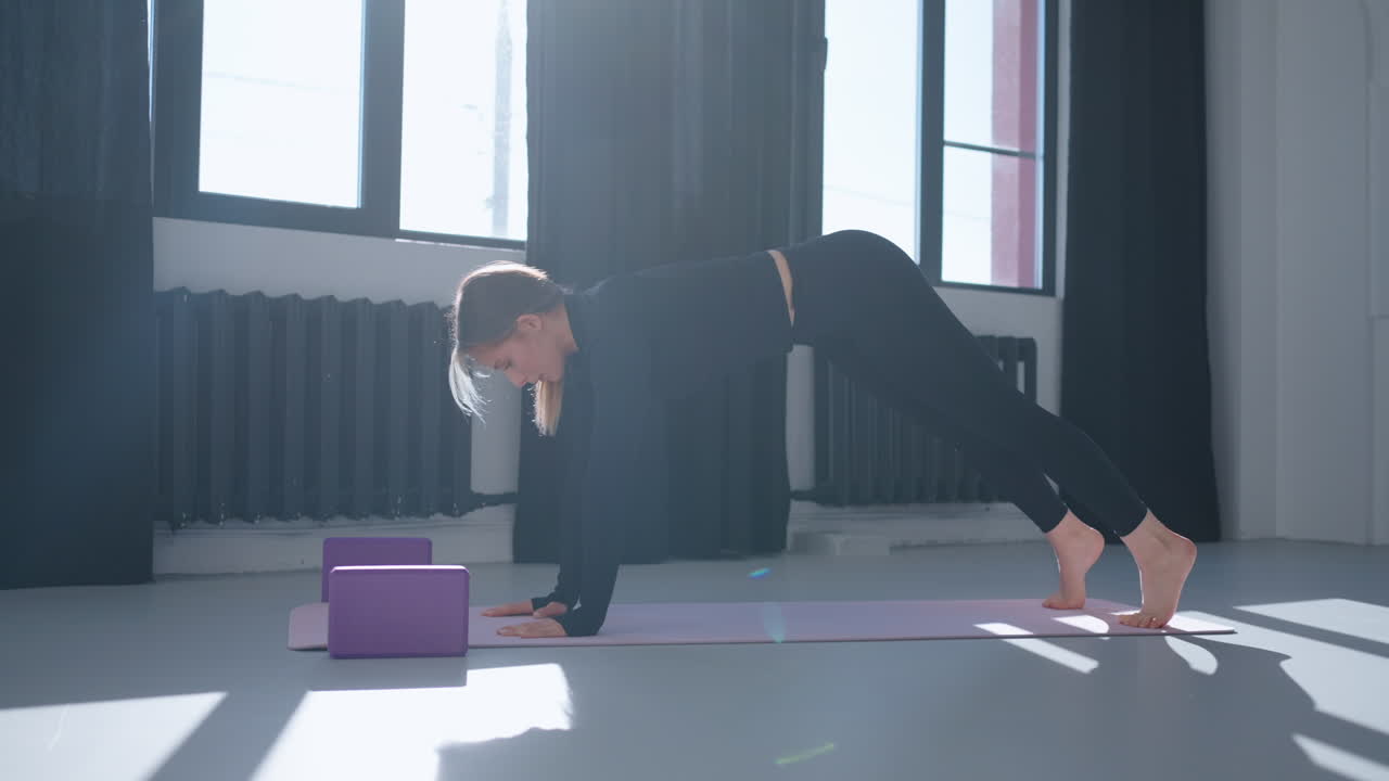 여성이 스튜디오에서 요가 포즈를 취하고 있습니다.