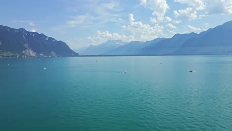 crane drone shot of the lake of geneva with the dents du midi moutain range behind