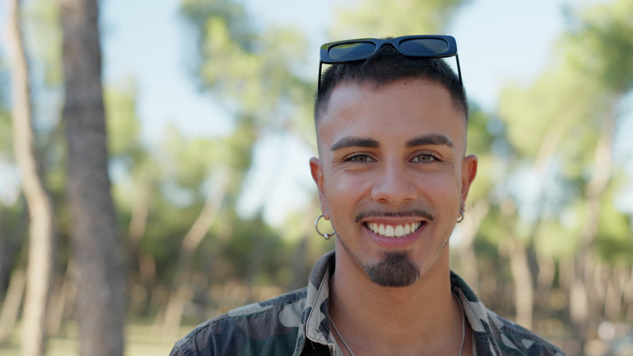 Close-up portrait of a smiling young man with sunglasses outdoors