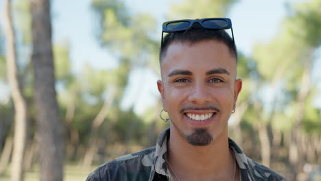 close-up portrait of a smiling young man with sunglasses outdoors