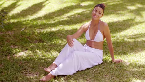 Smiling-friendly-young-woman-relaxing-in-a-garden