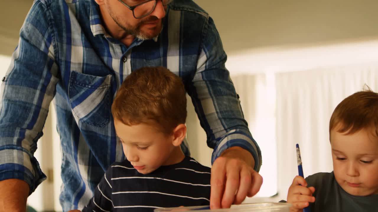 padre ayudando a sus hermanos con su tarea escolar 4k