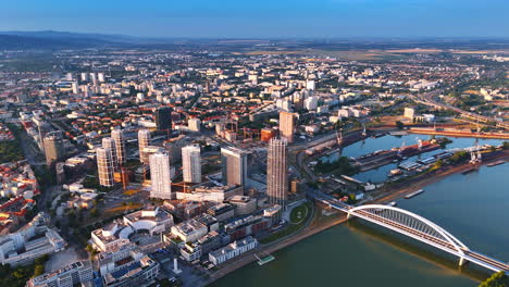modern part of bratislava, slovakia with high-rises and construction sites. drone footage above the danube on sunny day