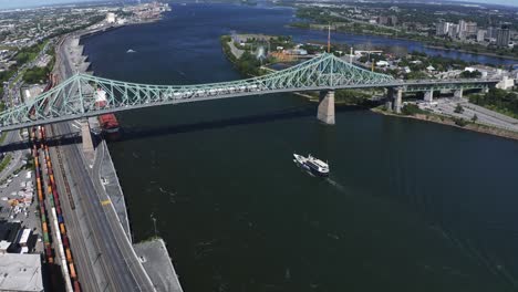 aerial view of the jacques cartier bridge in montreal, spanning the st. lawrence river. its iconic design and connection between the island and the south shore, with the city skyline in the backdrop.