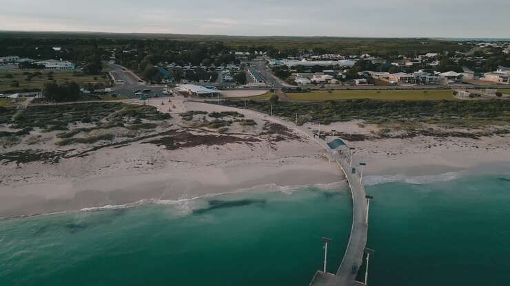 Filmato aereo cinematografico di Jurien Bay, con panoramica verso l'alto e intorno al pittoresco pontile per rivelare la città costiera