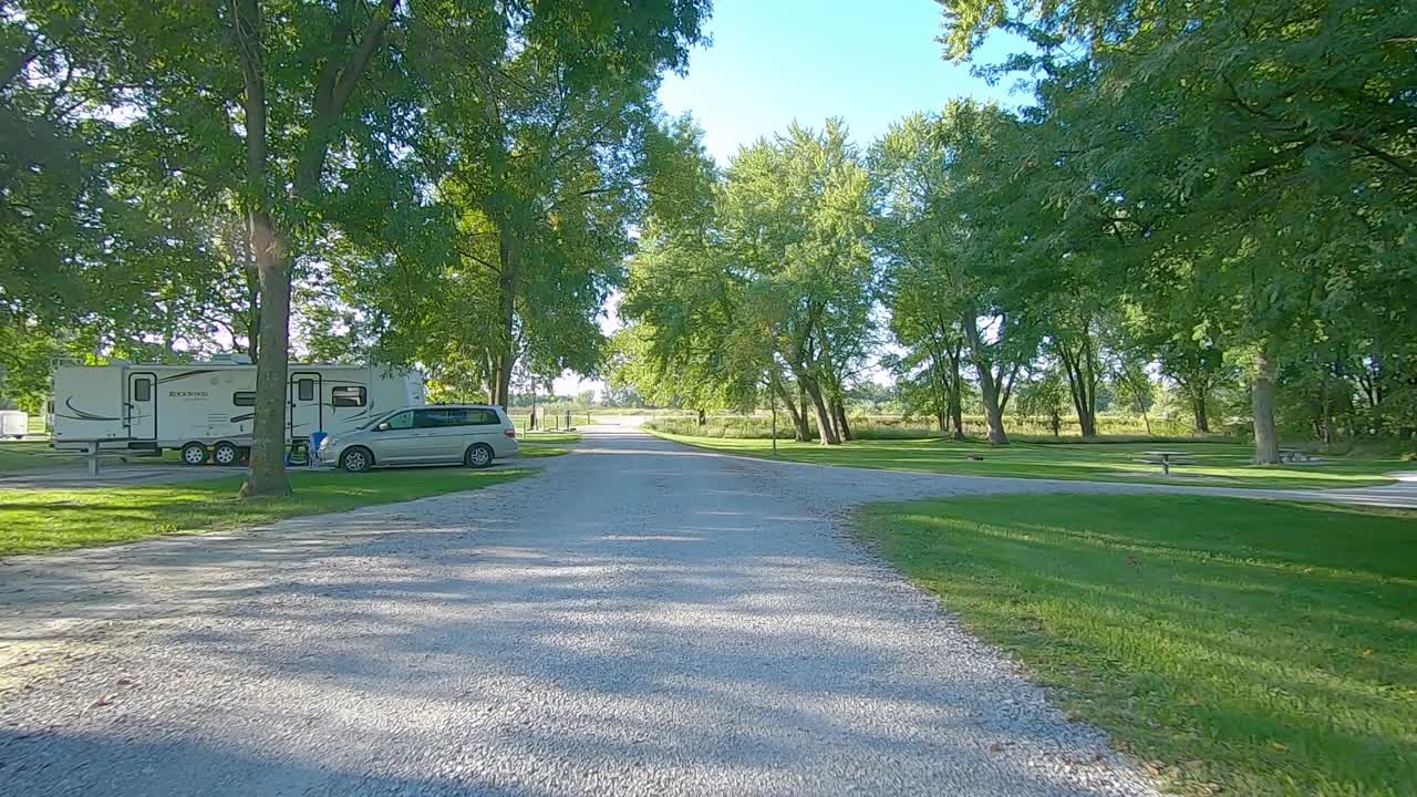 Giornata di sole in Iowa con POV che attraversa lentamente un campeggio con pochi ospiti a fine estate