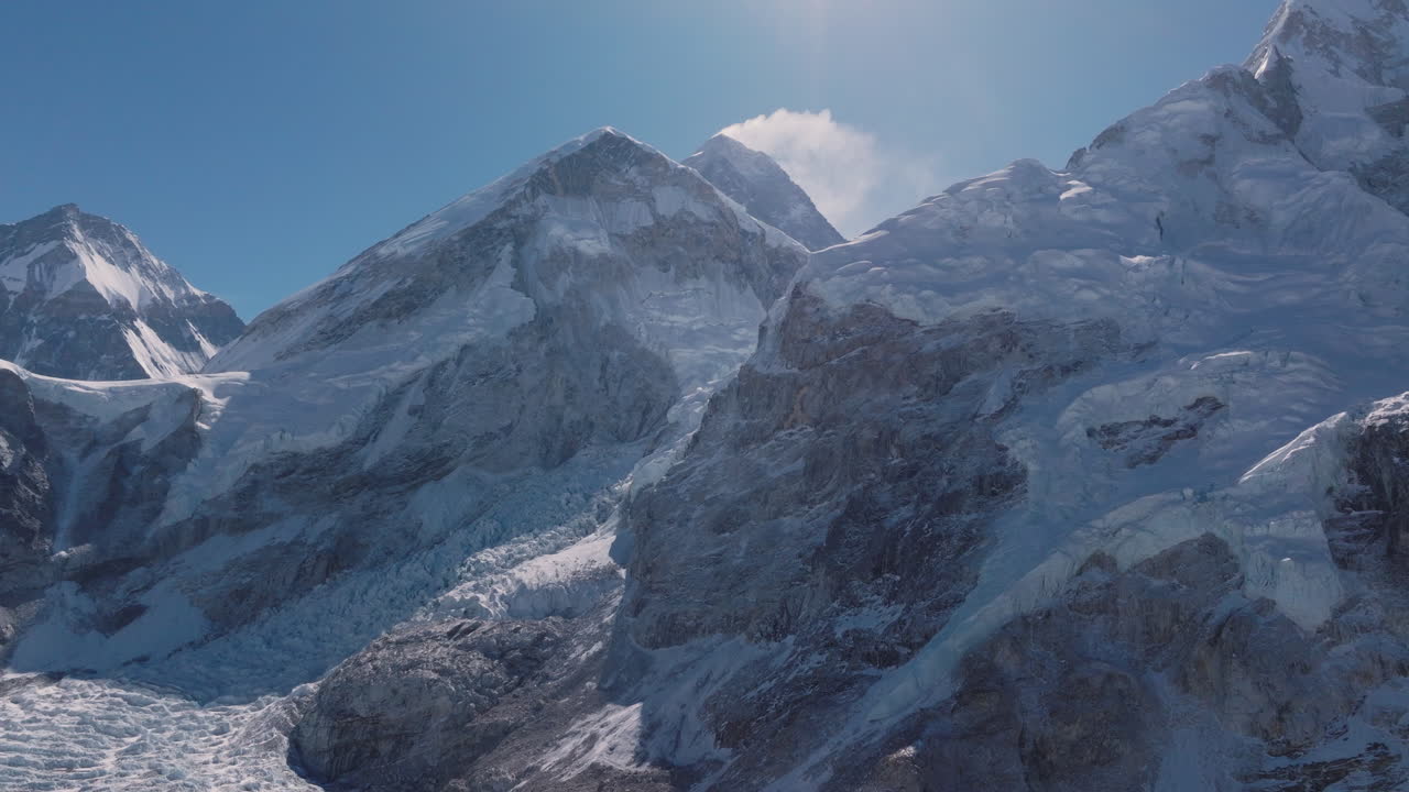 Drone view of Mount Everest mountain ranges with shining snow, clouds, and serene peaceful scenery in Nepal. World's highest peak base camp scenario, layered mountains adventurous travel and tourism