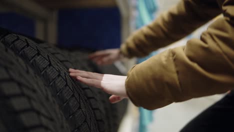 Man-choosing-new-tires-in-shot