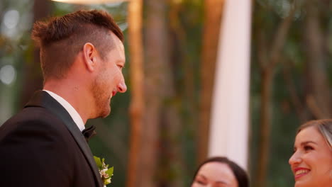 groom smiling at the bride during an outdoor wedding ceremony
