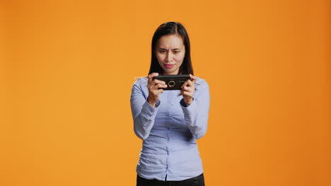joyful adult playing mobile videogames on camera