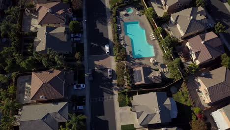 drone flying slowly over residential neighborhood with pool in the suburbs