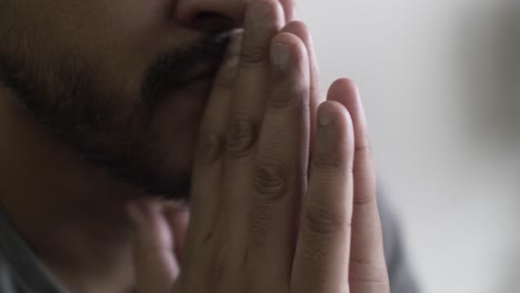 close up of asian male hands resting on mouth and tapping fingers