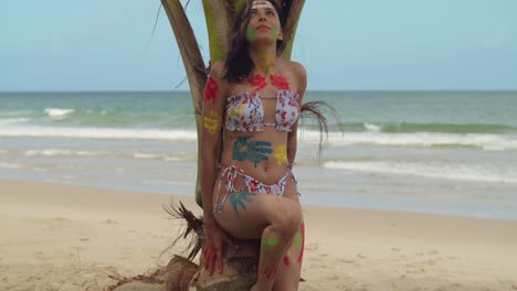 enjoying the caribbean sunshine, a girl wears body paint and a bikini on a white sand beach