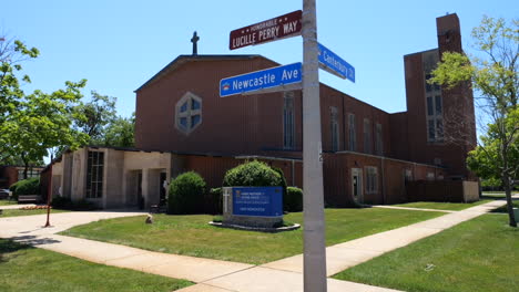 letreros de la calle frente a la iglesia católica del divino niño jesús en westchester, illinois, ee.uu.