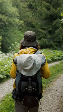 woman hiking in the woods with ukulele