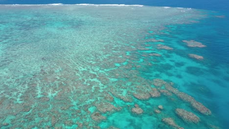 Antena-Hacia-Atrás-De-La-Gran-Barrera-De-Coral-Del-Ecosistema-De-Coral-Y-Agua-Colorida,-Cerca-De-Cairns,-Queensland,-Australia