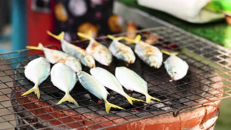 fresh mackerel grilling on a traditional thai barbecue