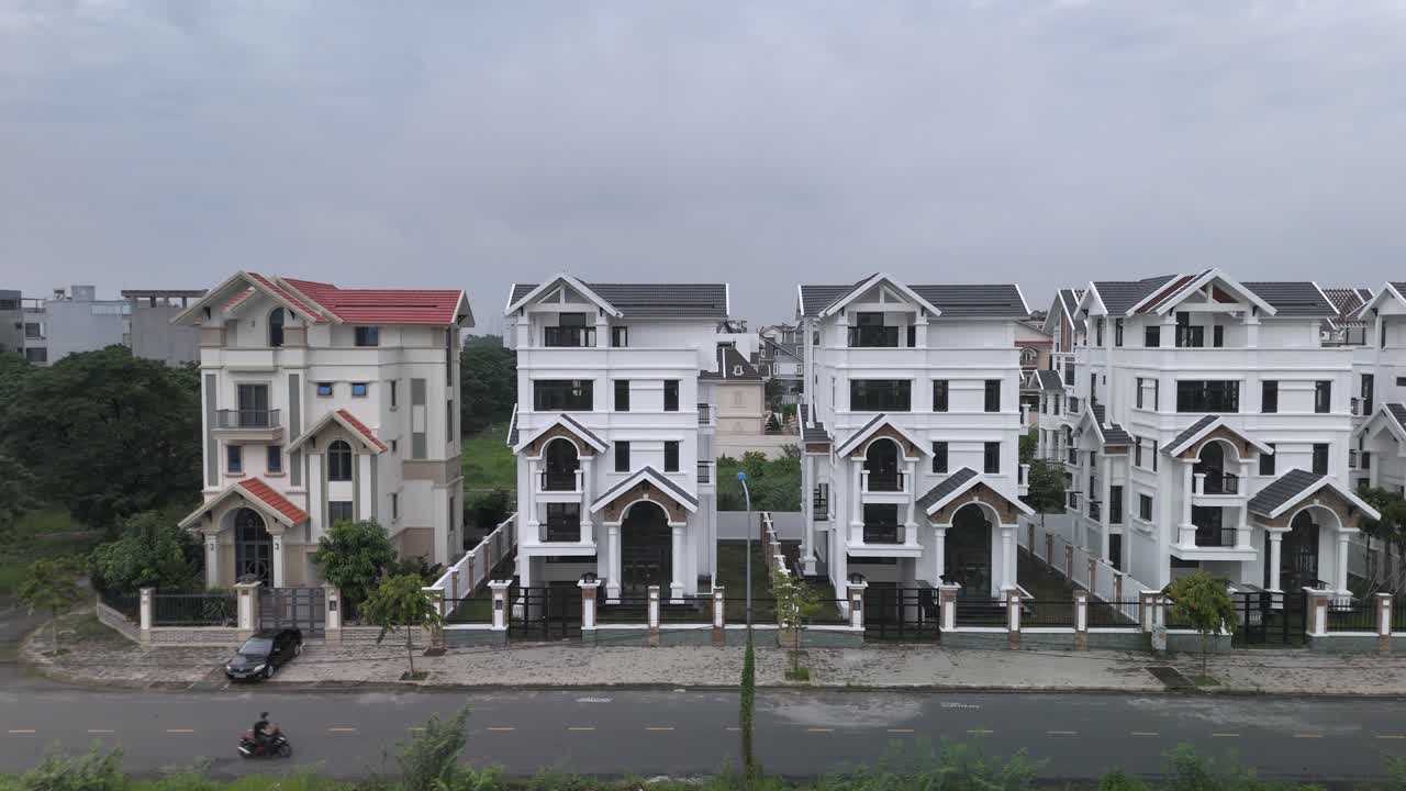 교외 도로를 따라 새로 지어진 동일한 큰 색 다층 빌라 스타일의 집들의 줄