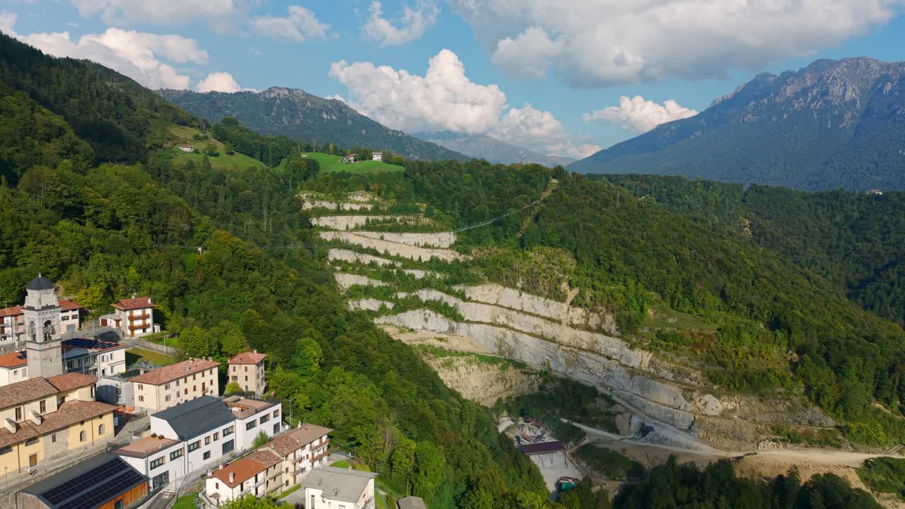 Aerial View of Tartano Italy Picturesque Village Nestled in the Italian Alps with Lush Green Mountains and Dramatic Quarry Landscape