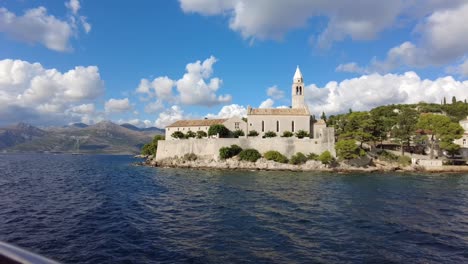 Coastal-view-of-Elafiti-Islands,-Croatia,-featuring-a-historic-church-under-a-vibrant-blue-sky