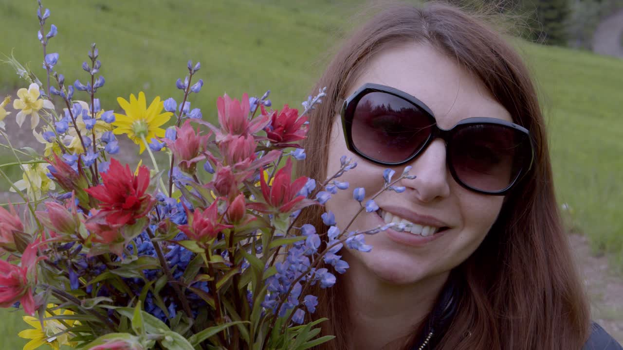 mujer con flores silvestres sonriendo y lanzando un beso