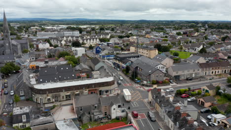Panorama-curve-shot-of-traffic-and-buildings-in-town-centre.-Cathedral-with-tall-spire.-Ennis,-Ireland
