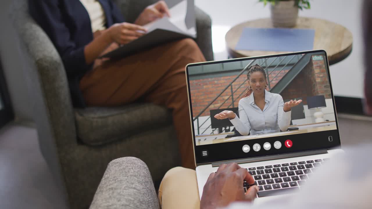African american man using laptop for video call, with business colleague on screen