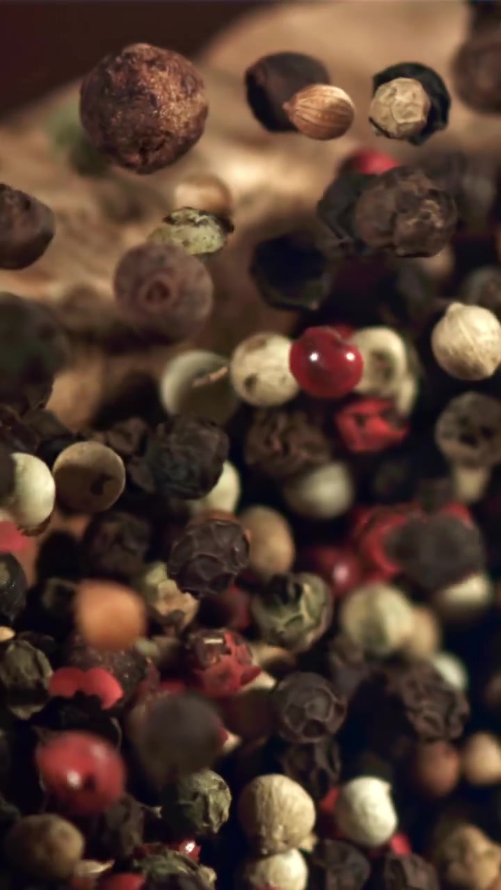 Mixed Peppercorns Falling in Slow Motion