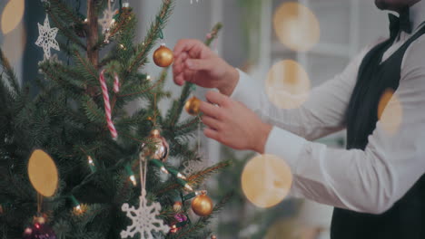 man decorating christmas tree at home