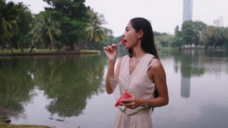 woman enjoying watermelon in a park