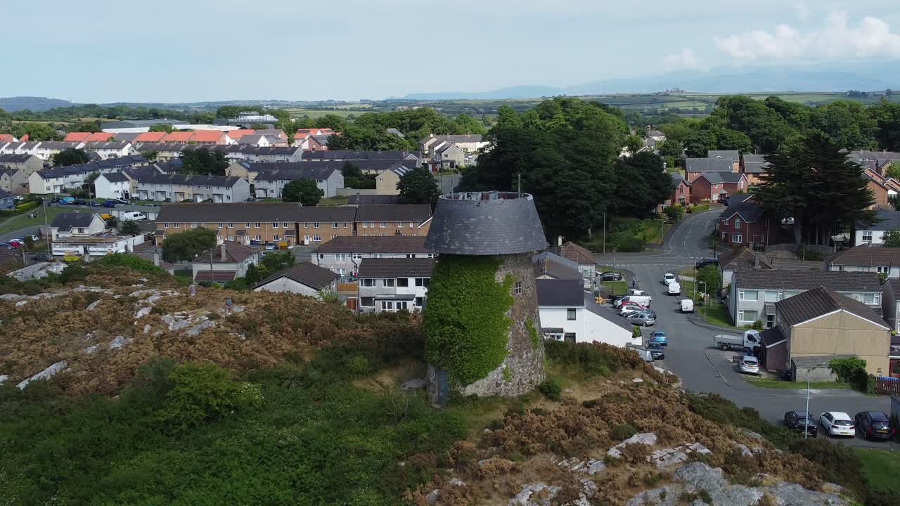 llangefni molino de viento vista aérea que se eleva sobre la ladera cubierta de hiedra punto de referencia con vistas a las montañas de snowdonia galés, anglesey