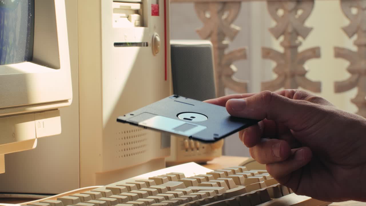 Using diskette for old computer. Music recorder, playing retro computer games. Vintage device for office, obsolete technology. . High quality 4k footage