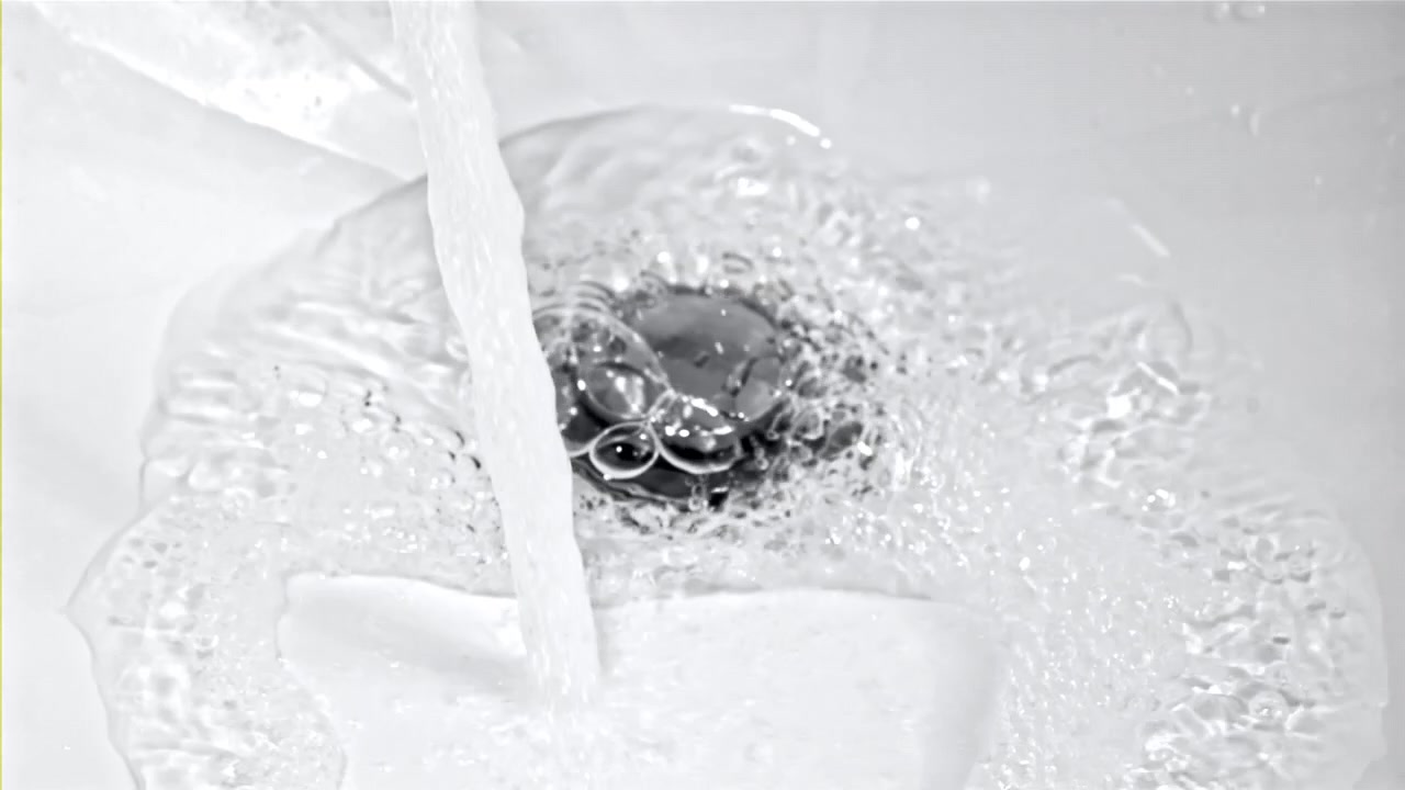 Clear Water Flowing and Bubbling Down a Sink Drain