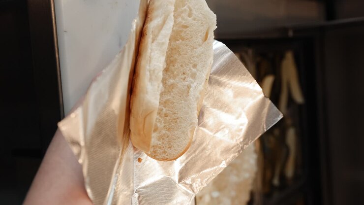 Close Up Shot of Roasted Wiener Being Placed in Hot Dog Bun