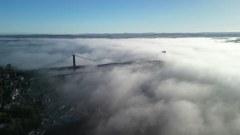 Dense-Morning-Fog-Covering-the-Tamar-Bridge-and-Royal-Albert-Bridge-Between-Devon-and-Cornwall,-Aerial-Panning-Shot-Above-the-Fog