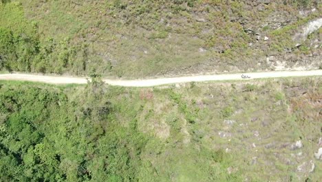conducción de automóviles a lo largo de un camino rural recto a lo largo del bosque de montaña