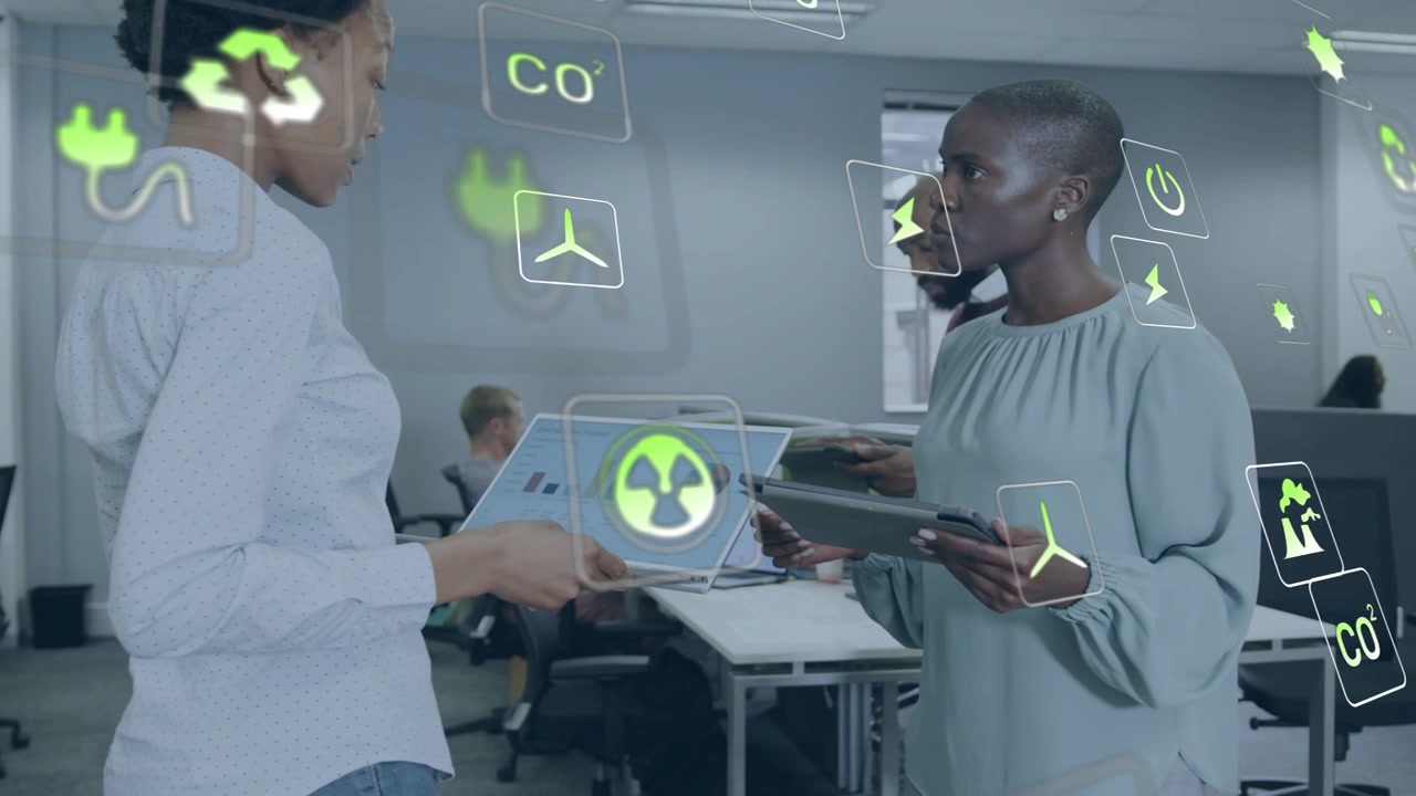 Left woman showing laptop charts right woman reading tablet in office icons occluding for eco plans