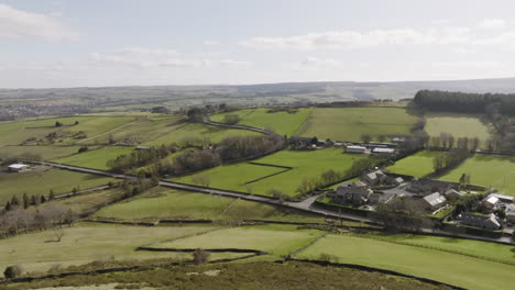 drone shot flying over hills and revealing green west yorkshire valley