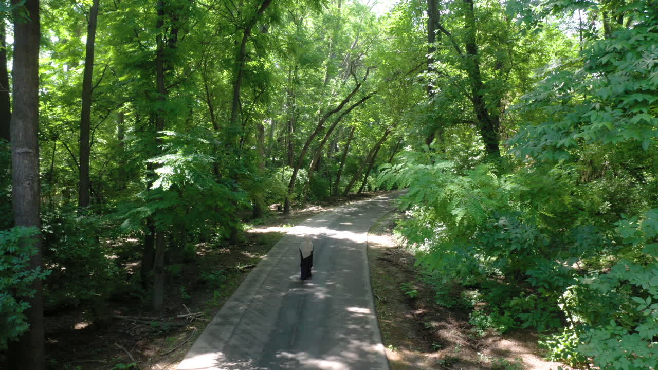 혼자 숲에서 걷는 이슬람 소녀