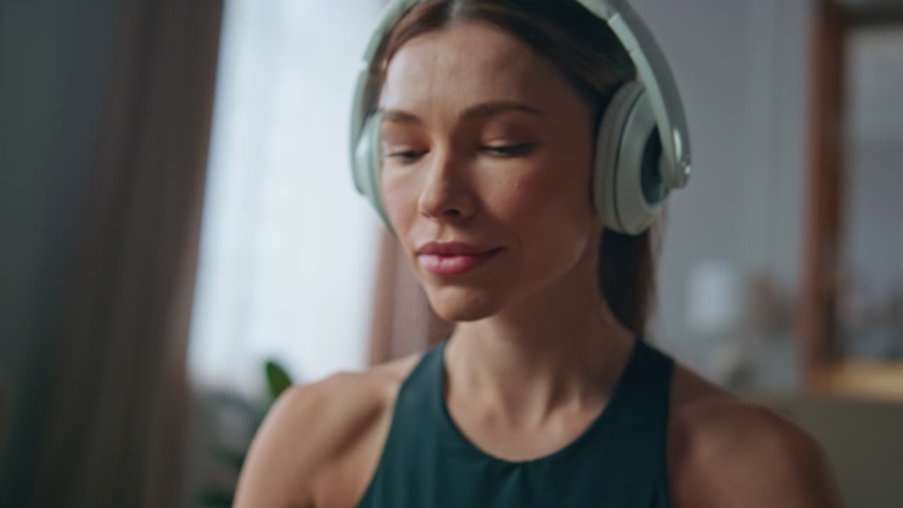 Closeup woman meditating earphones at apartment. Girl turning on smartphone yoga