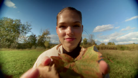 young woman holding autumn leaves