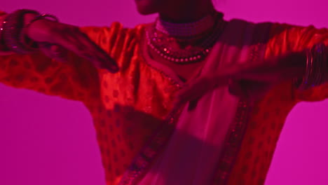 Close-Up-On-Hands-Of-Female-Kathak-Dancer-Performing-Dance-Wearing-Traditional-Indian-Dress-Against-Purple-Background-1