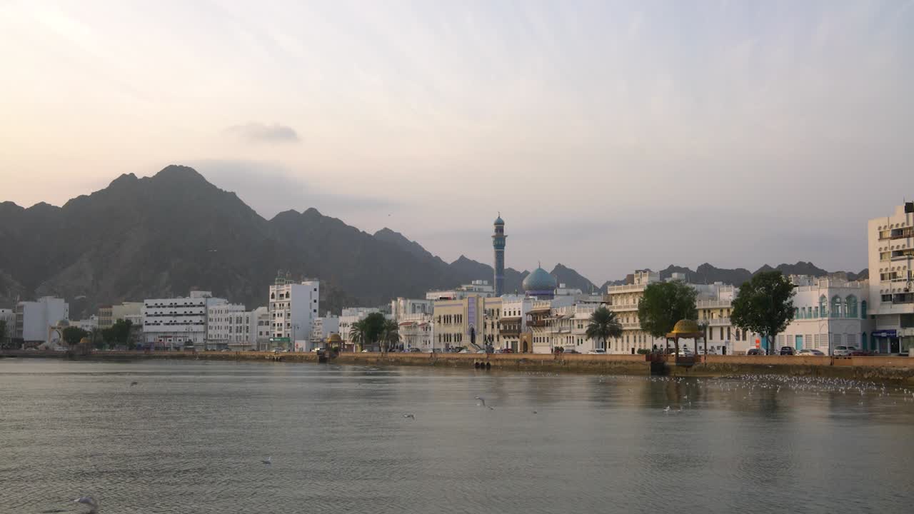 Corniche di Mutrah all'alba con gabbiani in volo e tempo calmo